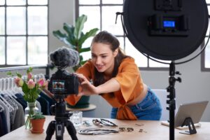 picture of woman adjusting a camera aimed at her